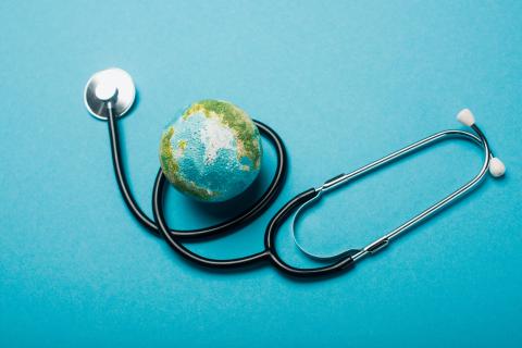 A stethoscope is looped around a model of the earth