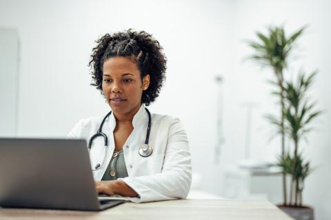 A doctor works at a computer