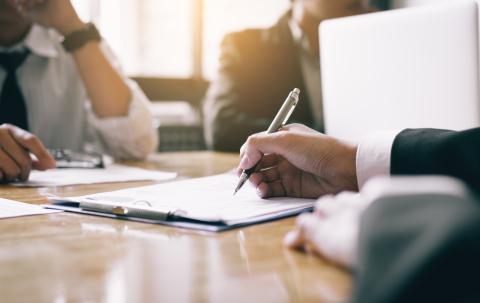 A group of businesspeople work together at a boardroom table