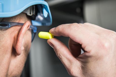 A worker puts in earplugs