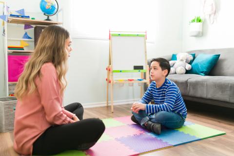 A psychologist plays on the floor with a child