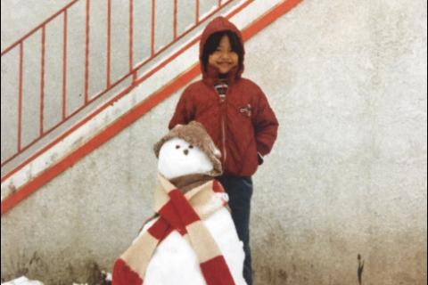 Dr Chung standing behind a snowman.