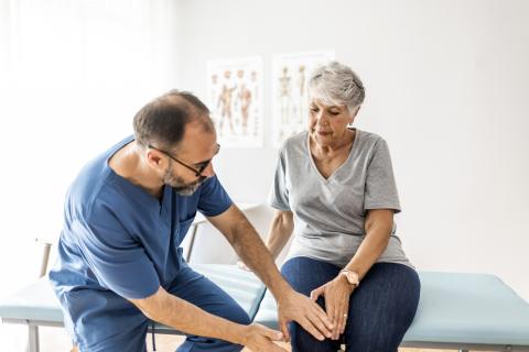A doctor examines a patient's knee.