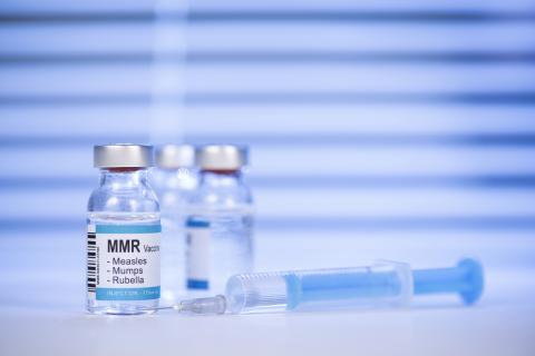 Two vials of the MMR vaccine and a syringe.