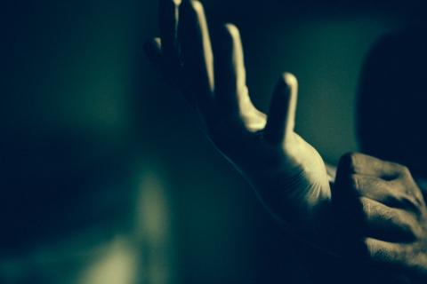 A close-up of two hands, one putting a latex glove on the other.