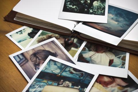 A scrapbook and a collection of Polaroid photos.