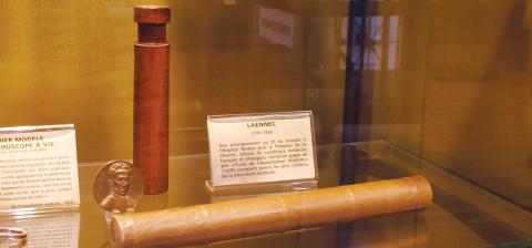 Two early stethoscopes, one made of tightly rolled paper and one made of wood.