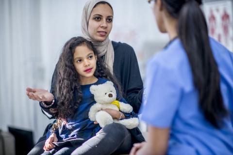 A doctor talks to a mother and daughter.