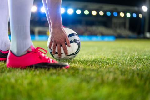 A soccer player gets ready to kick a soccer ball.
