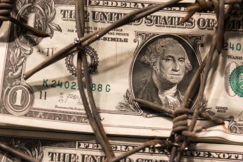 Closeup of Dollar Banknote with Barbed Wire