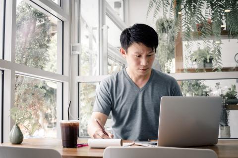 Young doctor watching a webinar on his laptop