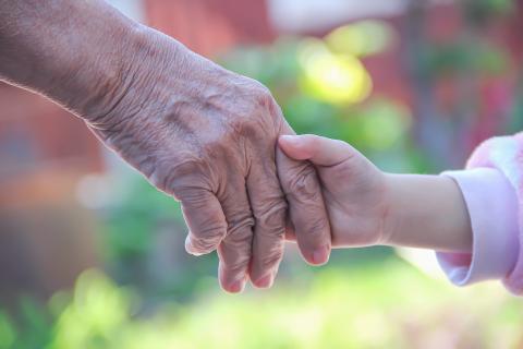 A grandmother and granddaughter hold hands