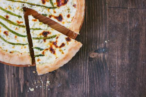 Divided asparagus pie or tart on wooden table