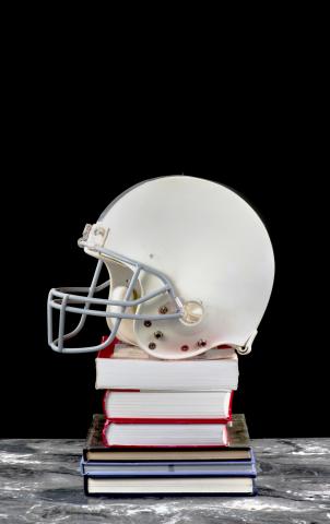 football helmet atop a pile of books