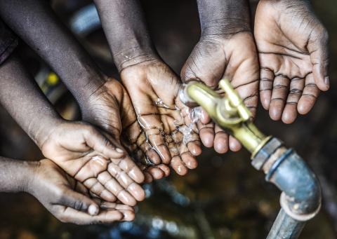 Symbol for fresh water for Africa, sets of hands under fresh pouring water