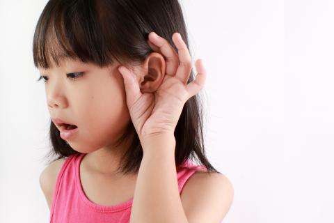 Little girl cupping her ear