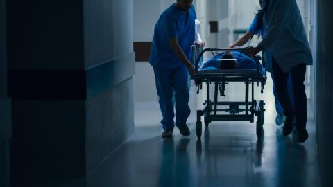 A gurney is rushed into the emergency department