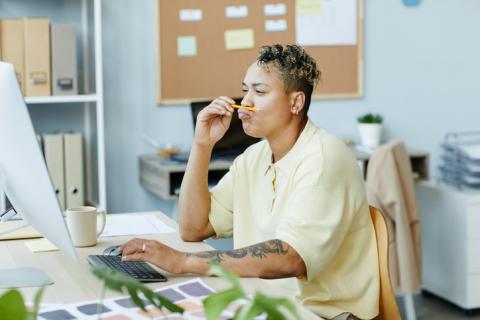 Woman playing with a pencil while working
