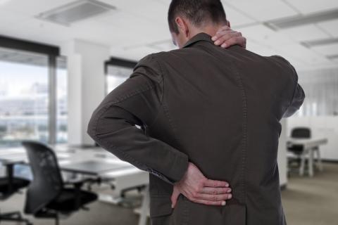 Business man with back pain in office
