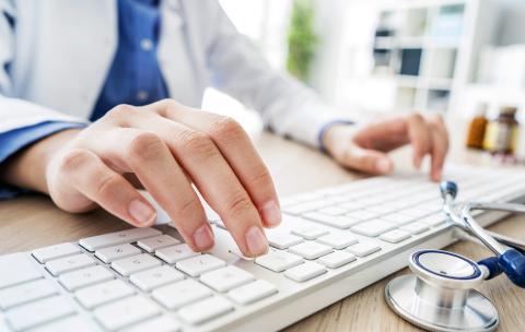 Doctor typing on a computer
