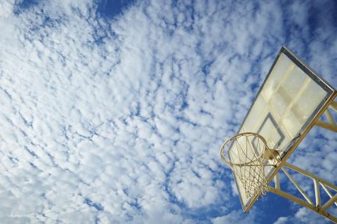 Blue sky with clouds and a basketball backboard