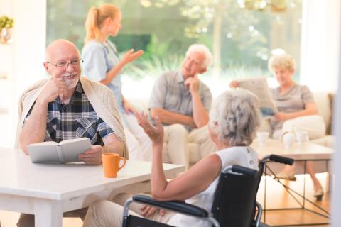 Senior man talking to a senior woman in a wheelchair
