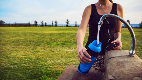 Female runner filling her bottle at a tap