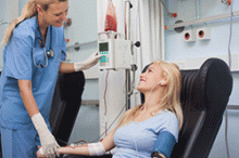 A nurse attends to a person donating blood