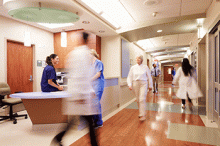 Doctors rush back and forth in a busy hospital
