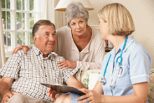 A home care nurse talks with a senior couple in their home