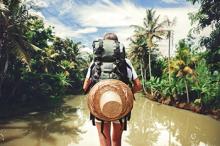 A backpacker walks through a rainforest