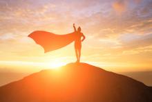 A silhouette of a woman with a superhero cape