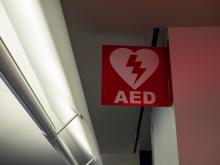 A sign with the abbreviation "AED" hangs in a hallway