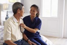 A doctor consults with a patient in their home