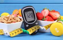 A bowl of cereal, a bowl of strawberries, a blood glucose meter, a tape measure, and free weights