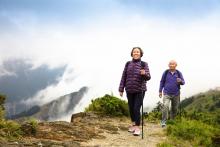A senior couple is walking on a trail