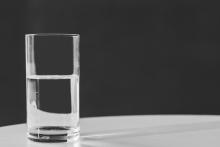 A glass of water sits on a table