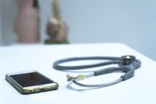 A stethoscope and a smart phone on a desk