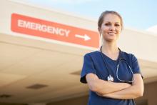 A doctor stands in front of a sign that says "Emergency"