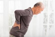 A man bends forward from back pain