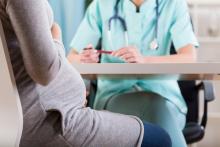 A pregnant woman talks with her doctor.