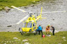 A patient on a stretcher is loaded onto a helicopter 