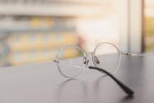 A pair of glasses sits on a table