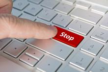 A computer keyboard with the word "Stop" on a large red button