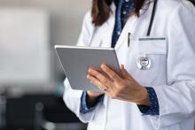 A doctor looks up information on a tablet