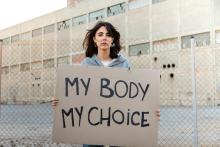 A woman holds a sign with the words "My body my choice"