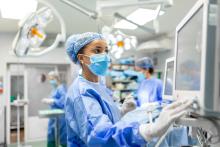 A surgeon looks at a monitor in an operating room