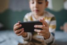 A young child uses a mobile phone.