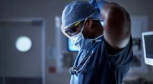 A doctor puts on a face mask.