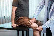 A doctor examines a patient’s knee.